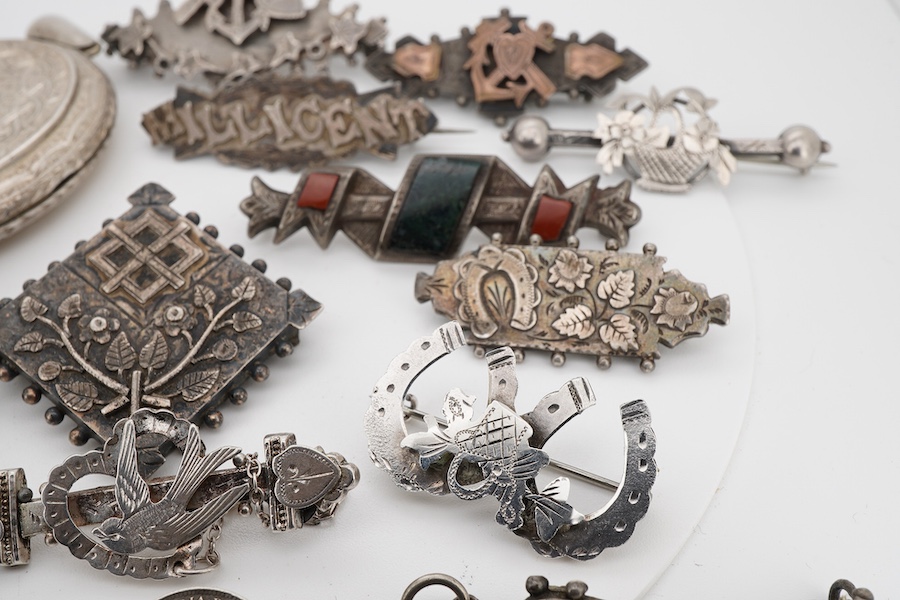 Ten assorted late 19th/early 20th century silver brooches, including three with names, Baby, Millicent and Ellen, together with five other white metal brooches including Scottish hardstones, a coin set stick pin, hardsto